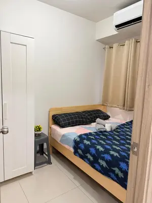 a bedroom with a bed with a blue blanket at S residence tower 3 Friendship family hotel in Manila