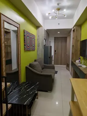a living room with a couch and a kitchen at S residence tower 3 Friendship family hotel in Manila