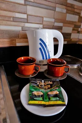 a book on a plate next to two cups and a mug at Sarasota Residential Resort Manila in Manila