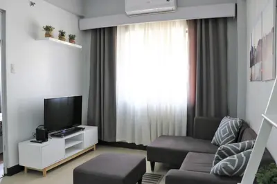 a living room with a couch and a tv at Sarasota Residential Resort Manila in Manila