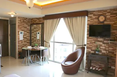 a living room with a chair and a table at Sarasota Residential Resort Manila in Manila