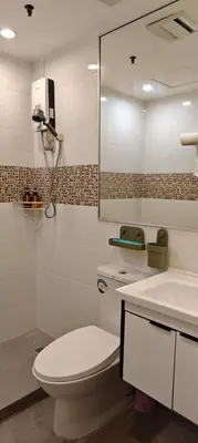 a bathroom with a toilet and a sink and a mirror at Touristation @ Crowne Bay Tower in Manila