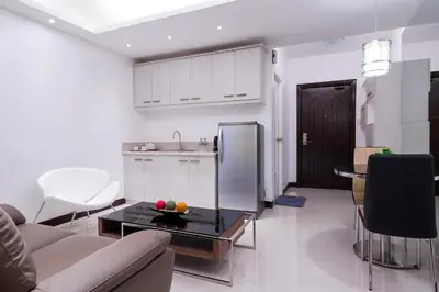 a kitchen and a living room with a couch and a table at Touristation @ Crowne Bay Tower in Manila