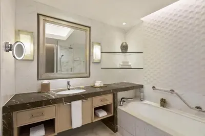 a bathroom with a sink and a tub and a mirror at Shangri-La The Fort, Manila in Manila