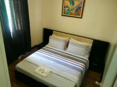 a bed in a room with two white pillows at Palm Tree Genlex Condo in Manila