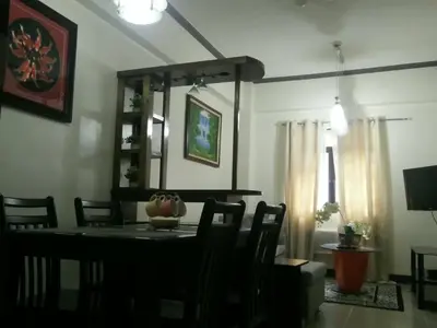 a dining room with a table and chairs at Palm Tree Genlex Condo in Manila