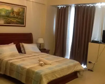 a bedroom with a bed with a stuffed animal on it at Palm Tree Genlex Condo in Manila