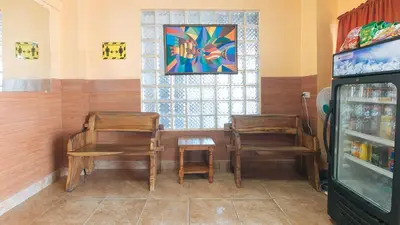 two chairs and a table in a room with a window at RedDoorz at Elegance Guest House near NAIA T3 in Manila