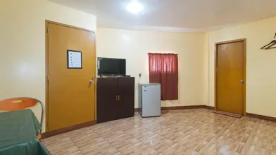 a living room with a television and a refrigerator at RedDoorz at Elegance Guest House near NAIA T3 in Manila