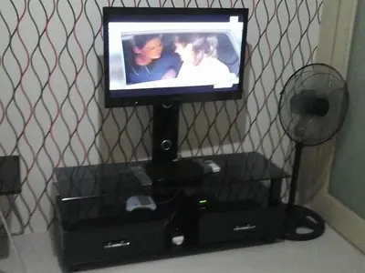 a flat screen tv on a stand with a fan at Sea Residences - Rheiyn in Manila