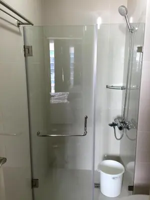 a bathroom with a glass shower with a toilet at One Palm Tree Villa CC9N in Manila