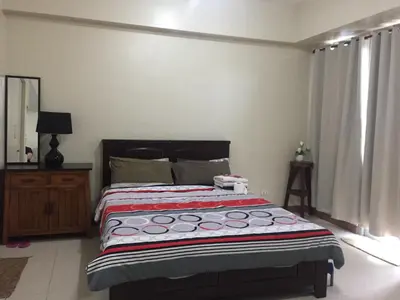 a bedroom with a bed with a red and white blanket at Love This Place in Manila