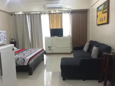 a living room with a bed and a couch at Love This Place in Manila