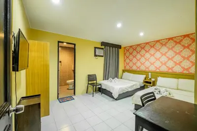 a hotel room with a bed and a bathroom at Hotel Juliano in Manila