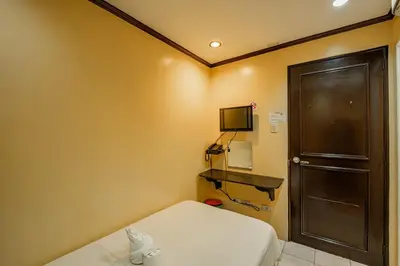 a small room with a bed and a television at Hotel Juliano in Manila