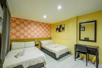 a hotel room with two beds and a mirror at Hotel Juliano in Manila