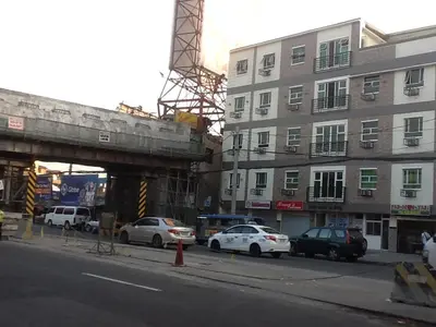 a city street with cars parked next to a building at AAM Transient and Guest House in Manila