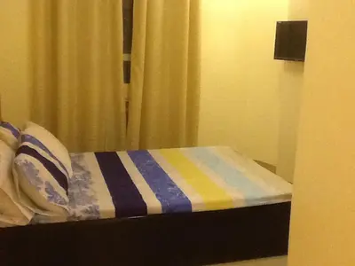a bed with a striped blanket and a window at AAM Transient and Guest House in Manila