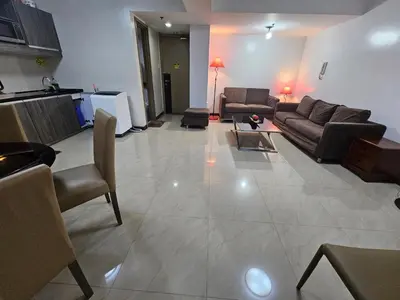 a large living room with couches and a table at Solemare Parksuites Condominium - Condo R Us in Manila