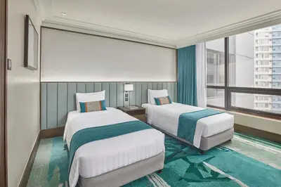 a hotel room with two beds and a window at Holiday Inn & Suites Manila Galleria by IHG in Manila