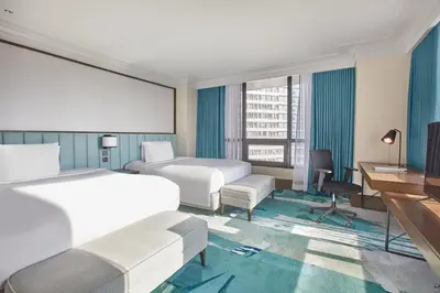 a hotel room with two beds and a desk at Holiday Inn & Suites Manila Galleria by IHG in Manila