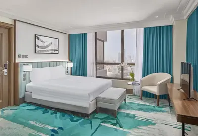 a hotel room with a bed and a desk and a television at Holiday Inn & Suites Manila Galleria by IHG in Manila