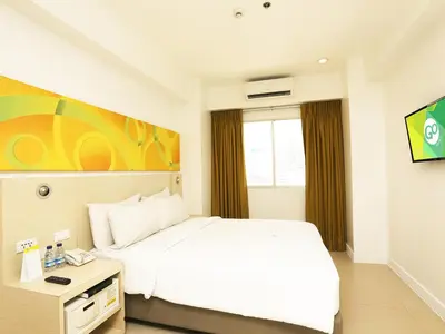 a bedroom with a white bed and a window at Go Hotels Manila Airport Road in Manila
