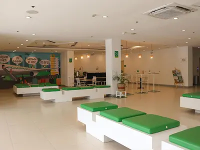 a restaurant with green and white tables and chairs at Go Hotels Manila Airport Road in Manila