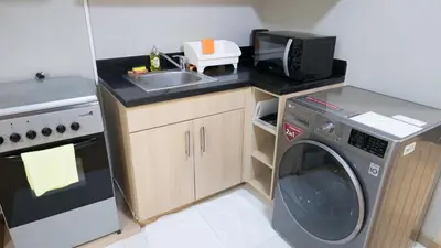 a small kitchen with a sink and a washing machine at Avant Serviced Suites - Personal Concierge in Manila