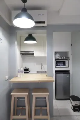 a kitchen with a counter and stools in it at Dragonfly Apartments and Transient House in Bacoor