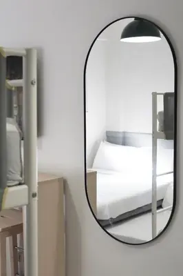 a mirror on a wall next to a bed at Dragonfly Apartments and Transient House in Bacoor