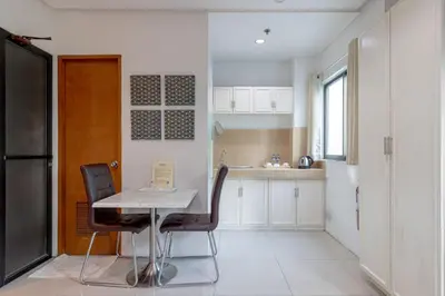 a kitchen with a table and chairs in a room at Baymont Suites & Residences in Manila