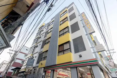 a yellow and white building on a city street at Baymont Suites & Residences in Manila