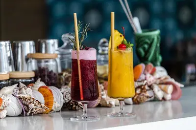 two cocktails sitting on top of a table with snacks at Shangri-La Residences The Fort, Manila in Manila