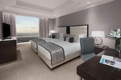 a bedroom with a bed and a desk and a television at Shangri-La Residences The Fort, Manila in Manila