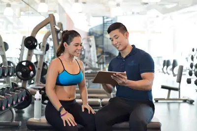 a man and a woman in a gym with a tablet at Shangri-La Residences The Fort, Manila in Manila