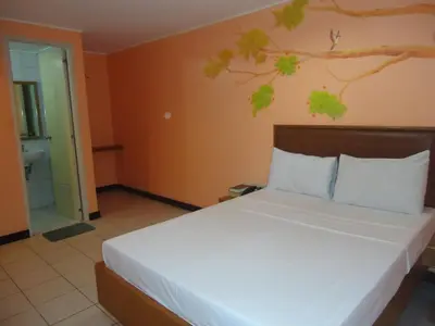 a bedroom with a large bed and a bathroom at Park Bed and Breakfast Hotel Pasay in Manila