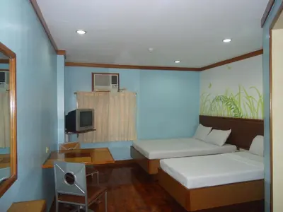 a small room with two beds and a tv at Park Bed and Breakfast Hotel Pasay in Manila
