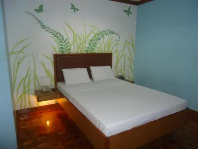 a bed in a room with plants on the wall at Park Bed and Breakfast Hotel Pasay in Manila