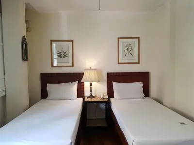 two beds in a room with a table and a lamp at Charming La Casita Mercedes, 5Br and 5TB for Family and Friends Staycation- Read Listing Info in Manila