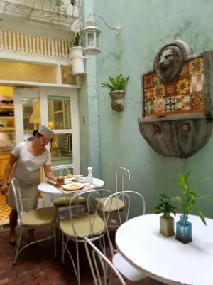 a woman sitting at a table in a restaurant at Charming La Casita Mercedes, 5Br and 5TB for Family and Friends Staycation- Read Listing Info in Manila
