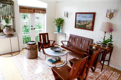 a living room with wooden chairs and a table at Charming La Casita Mercedes, 5Br and 5TB for Family and Friends Staycation- Read Listing Info in Manila