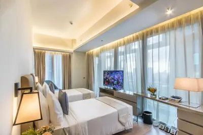a bedroom with two beds and a large window at I'M Hotel in Manila