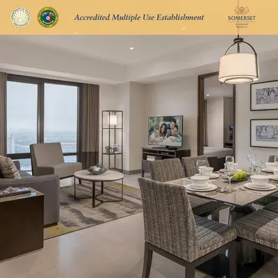 a dining room and living room with a table and chairs at Somerset Alabang Manila in Manila