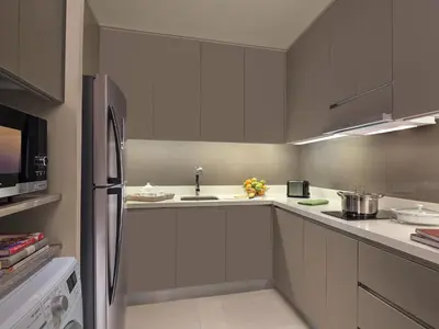 a kitchen with white cabinets and a stainless steel refrigerator at Somerset Alabang Manila in Manila