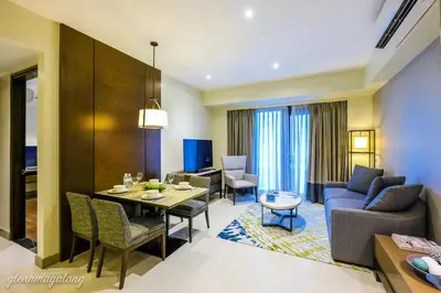 a living room with a dining table and a living room at Somerset Alabang Manila in Manila