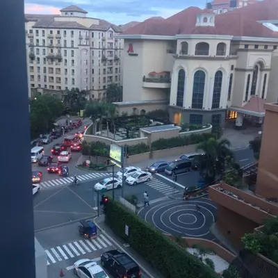 a city street with cars parked in a parking lot at Palm Tree Villas by Ann in Manila