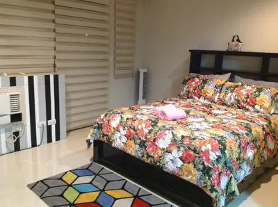 a bedroom with a bed with a colorful quilt at Palm Tree Villas by Ann in Manila