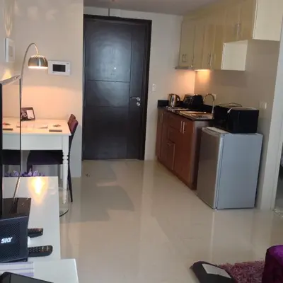 a kitchen with a black door and a refrigerator at Palm Tree Villas by Ann in Manila