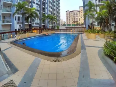 a large swimming pool in the middle of a building at Palm Tree Villas by Ann in Manila